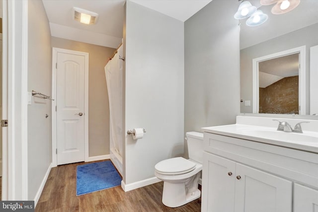 bathroom featuring walk in shower, vanity, hardwood / wood-style floors, and toilet