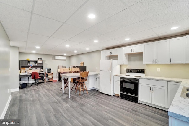 kitchen featuring a paneled ceiling, white appliances, white cabinetry, and light hardwood / wood-style flooring