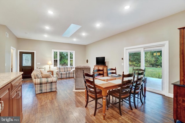 dining area featuring dark wood-type flooring and a skylight