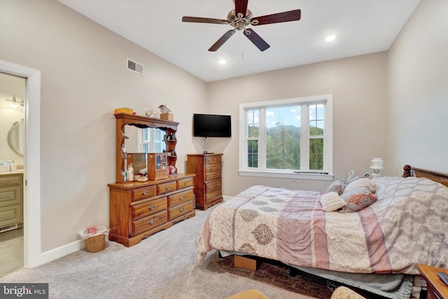 bedroom featuring connected bathroom, ceiling fan, and light colored carpet