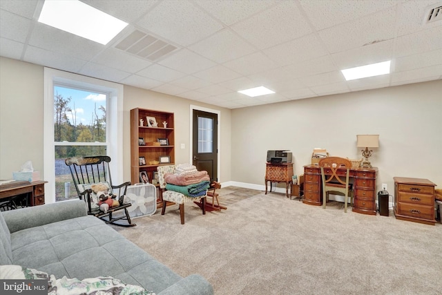 interior space featuring light colored carpet and a paneled ceiling