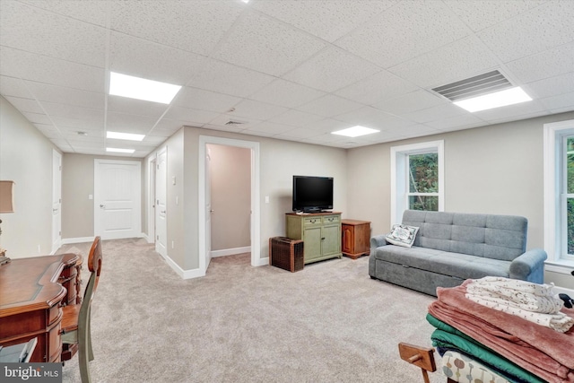 carpeted living room with a paneled ceiling