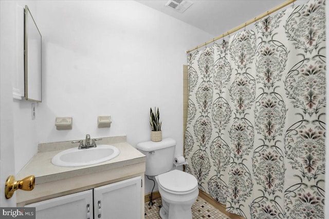 bathroom with tile patterned flooring, walk in shower, vanity, and toilet