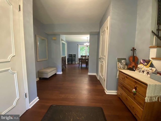 hall with a notable chandelier and dark wood-type flooring