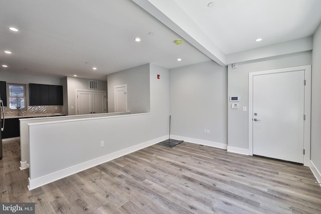 foyer entrance with beam ceiling and light hardwood / wood-style floors