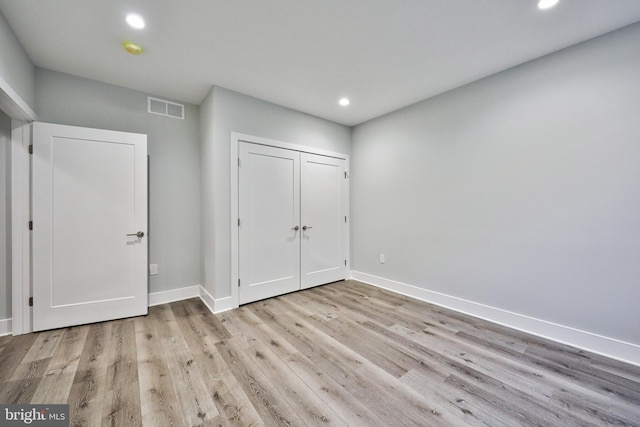 unfurnished bedroom featuring light wood-type flooring and a closet