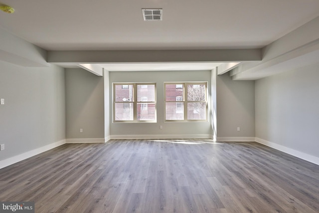 unfurnished room with beamed ceiling and hardwood / wood-style flooring