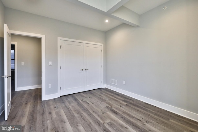 unfurnished bedroom featuring wood-type flooring and a closet