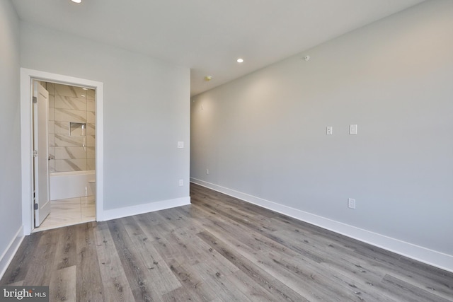 unfurnished bedroom with light hardwood / wood-style floors and ensuite bathroom