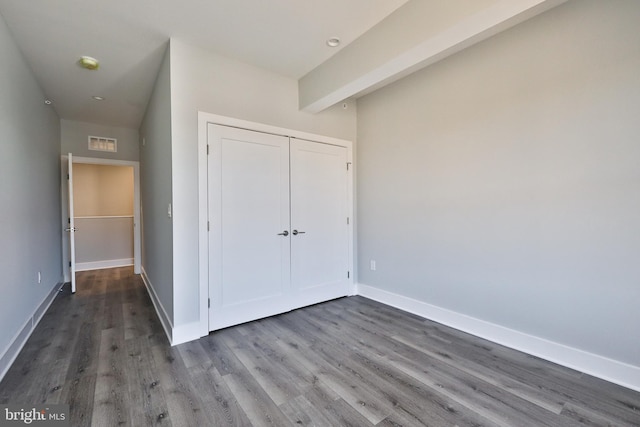 unfurnished bedroom with hardwood / wood-style flooring and a closet