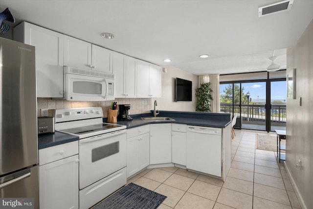 kitchen featuring kitchen peninsula, sink, white appliances, backsplash, and white cabinetry