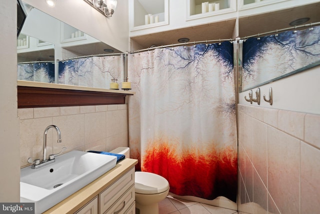 bathroom with tile walls, tile patterned flooring, toilet, vanity, and curtained shower