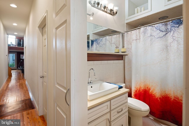 bathroom with hardwood / wood-style floors, curtained shower, vanity, and toilet