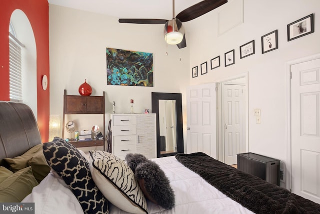 bedroom featuring ceiling fan and a high ceiling