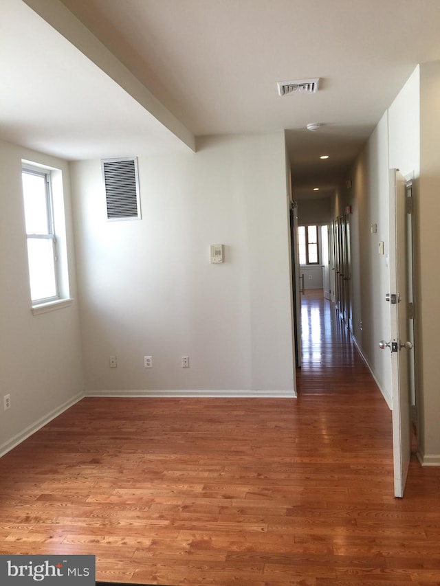 spare room with hardwood / wood-style flooring and plenty of natural light