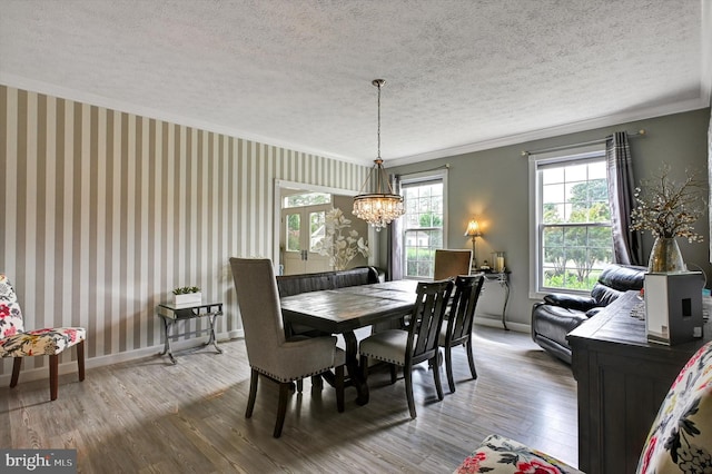 dining area featuring a chandelier, crown molding, hardwood / wood-style flooring, and a textured ceiling