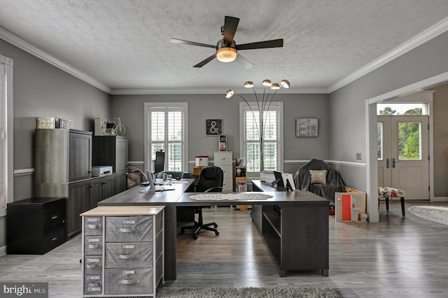 office space with a wealth of natural light, hardwood / wood-style floors, crown molding, and a textured ceiling