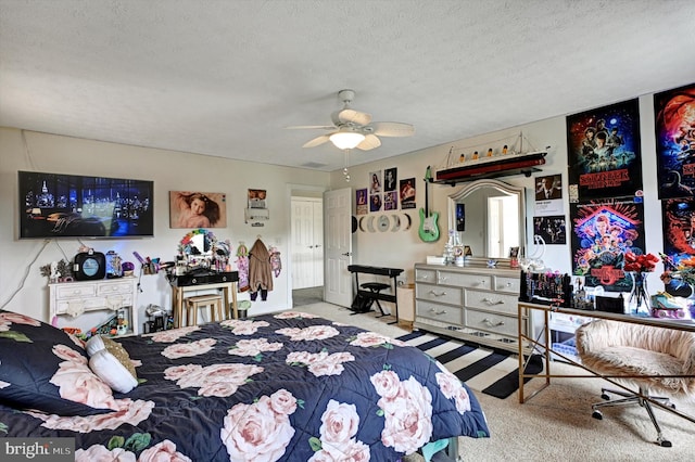 carpeted bedroom featuring ceiling fan and a textured ceiling