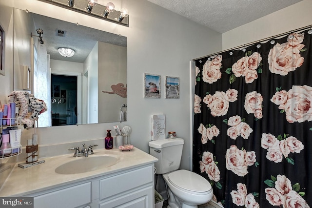 bathroom with vanity, toilet, a textured ceiling, and curtained shower