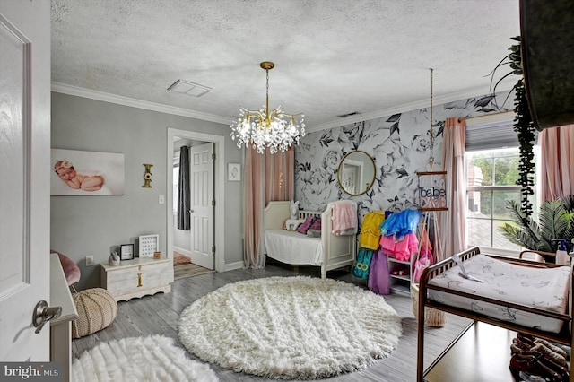 bedroom featuring crown molding, a textured ceiling, a chandelier, and hardwood / wood-style floors