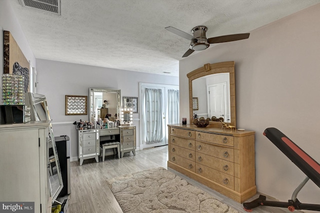 interior space featuring ceiling fan, a textured ceiling, and light wood-type flooring