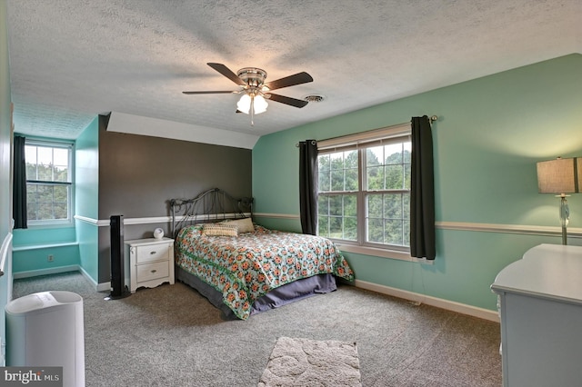 bedroom with ceiling fan, a textured ceiling, and multiple windows