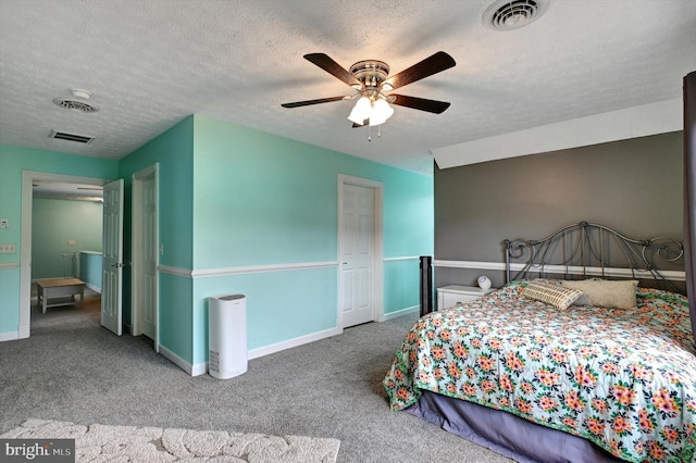 carpeted bedroom with ceiling fan and a textured ceiling