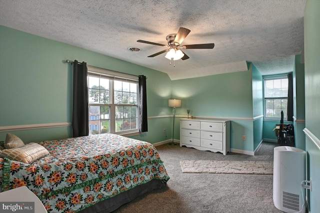 carpeted bedroom featuring multiple windows, a textured ceiling, and ceiling fan