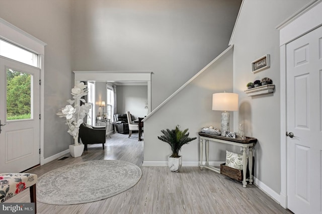 foyer entrance with crown molding and light wood-type flooring