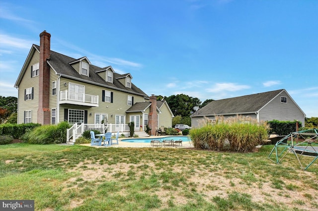 back of house featuring a patio area, a yard, and a balcony