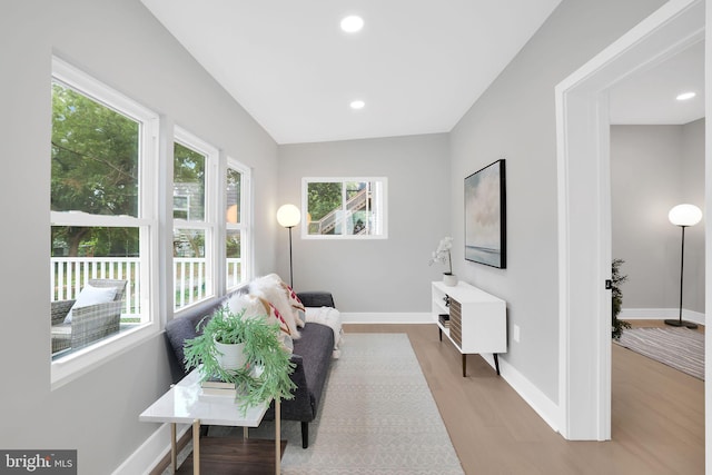 living area featuring light wood-type flooring and vaulted ceiling