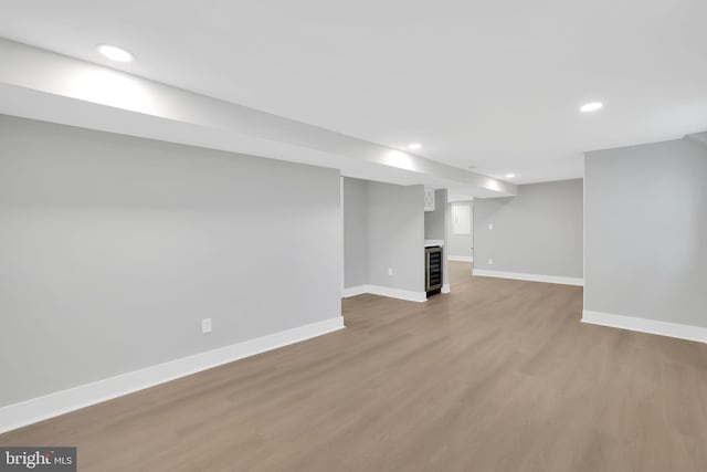 basement with wine cooler and hardwood / wood-style flooring