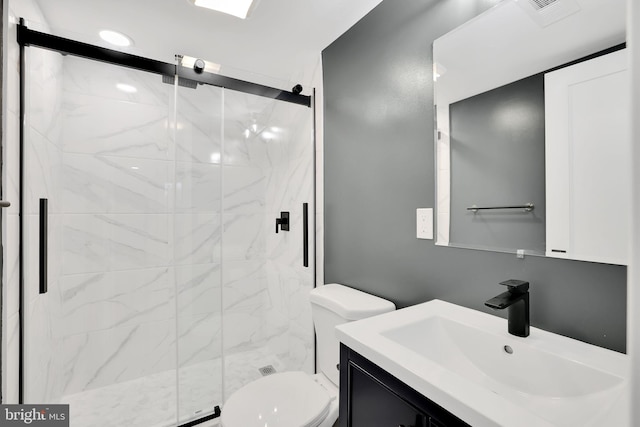 bathroom with vanity, toilet, and a shower with door