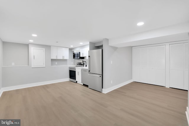 basement with light hardwood / wood-style flooring and white fridge