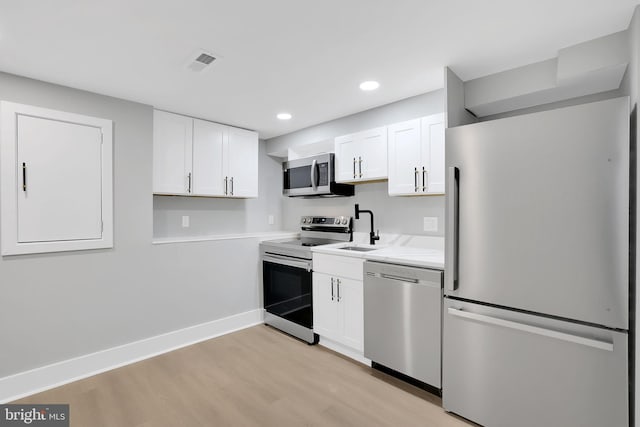 kitchen featuring light hardwood / wood-style floors, sink, stainless steel appliances, and white cabinets