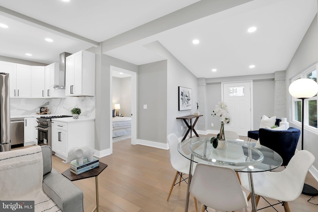 dining room featuring lofted ceiling and light wood-type flooring