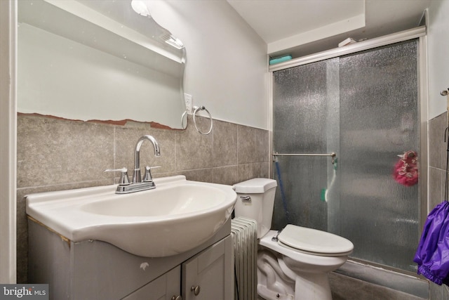 bathroom featuring vanity, tile walls, toilet, and an enclosed shower