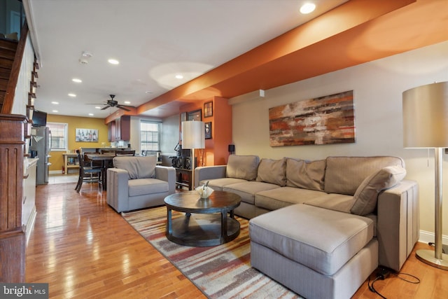 living room featuring light hardwood / wood-style floors and ceiling fan