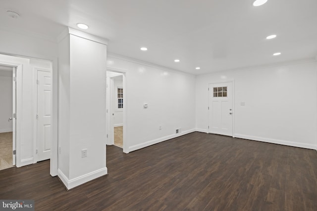 spare room featuring ornamental molding and dark wood-type flooring