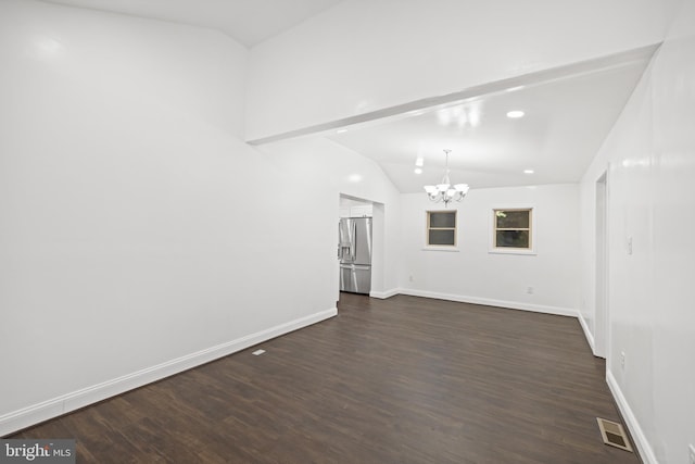 unfurnished living room featuring dark wood-type flooring, a chandelier, and vaulted ceiling