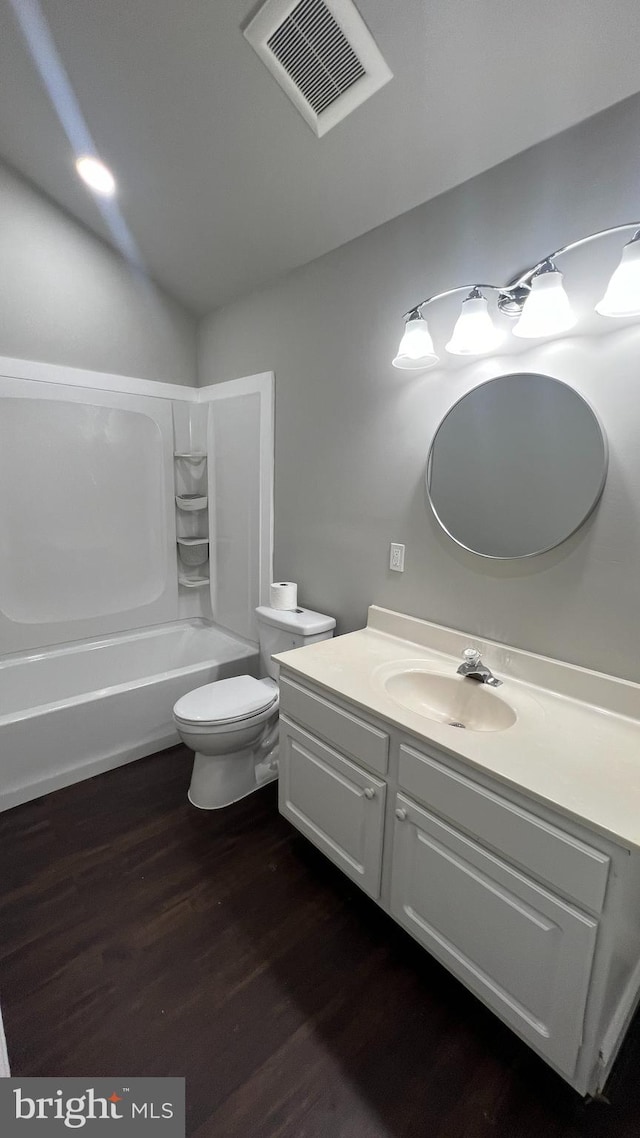 full bathroom with toilet, vanity, hardwood / wood-style floors, and shower / washtub combination