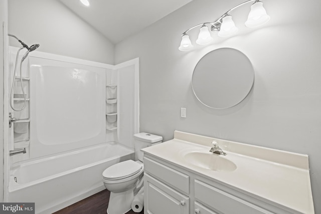 full bathroom with vanity, hardwood / wood-style flooring, toilet, washtub / shower combination, and lofted ceiling