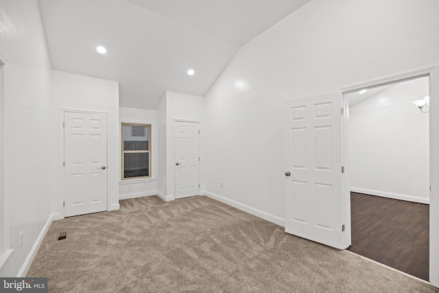 spare room with carpet flooring and lofted ceiling