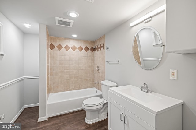 full bathroom with toilet, tiled shower / bath combo, vanity, and wood-type flooring