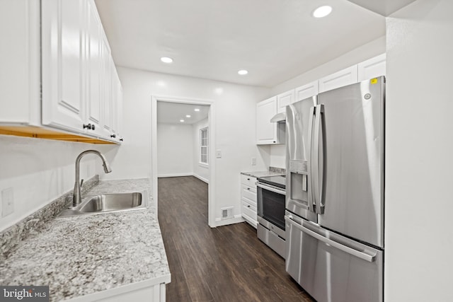 7213 Tyler Ave, Falls Church, VA 22042 - kitchen with a sink, stainless steel appliances, under cabinet range hood, dark wood-style flooring, and white cabinets