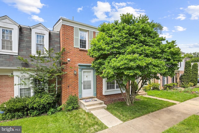 townhome / multi-family property featuring a front lawn