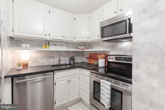 kitchen featuring appliances with stainless steel finishes, decorative backsplash, white cabinetry, and sink