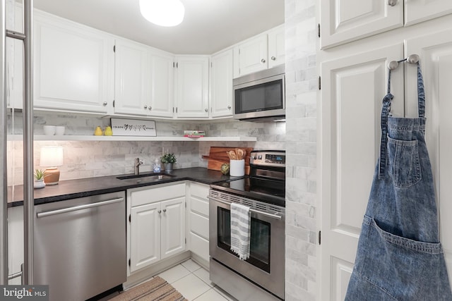 kitchen with appliances with stainless steel finishes, decorative backsplash, white cabinetry, and sink