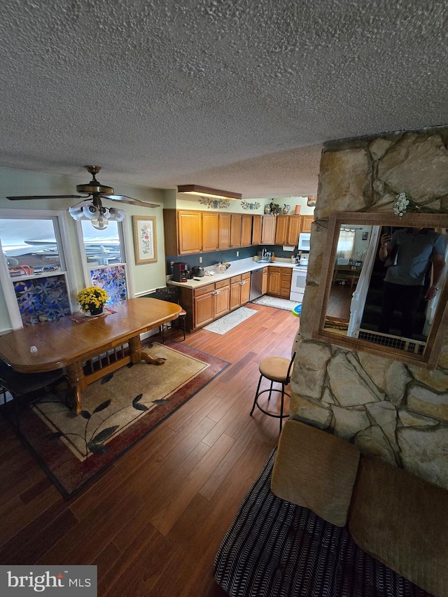 living room with a textured ceiling, hardwood / wood-style floors, and ceiling fan