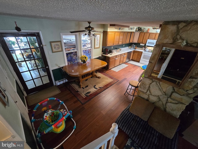 interior space featuring light wood-type flooring, a textured ceiling, baseboard heating, and ceiling fan